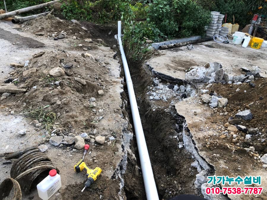 굴착한 땅속에 길게 매설된 새 PVC 배관