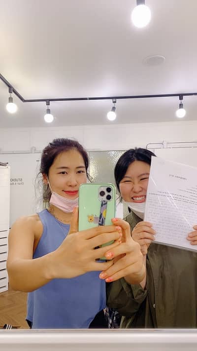 환한 미소를 지으며 회원 수강후기를 들어 보이는 모습