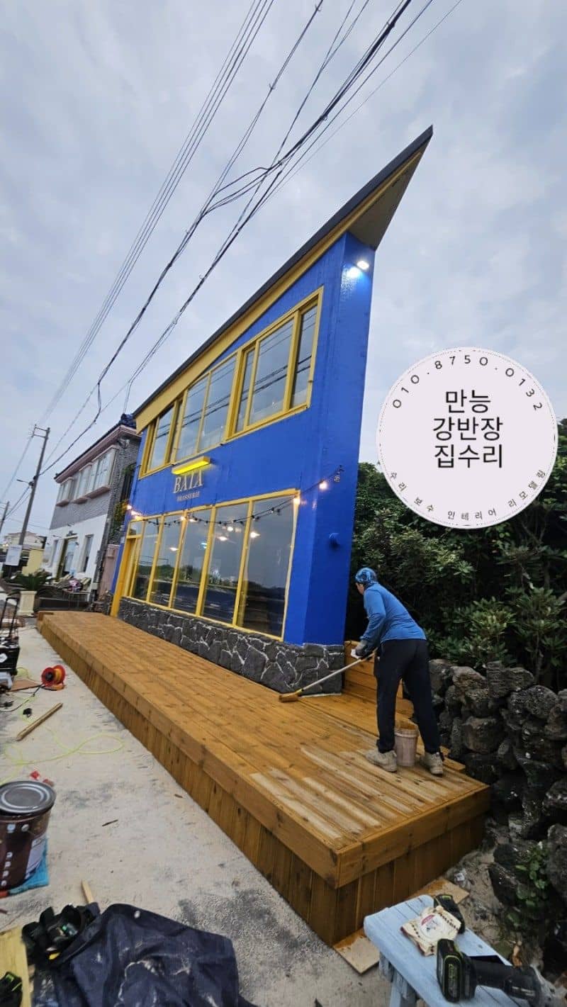 작업자가 방부목 데크 위에 오일스텐을 칠하는 모습