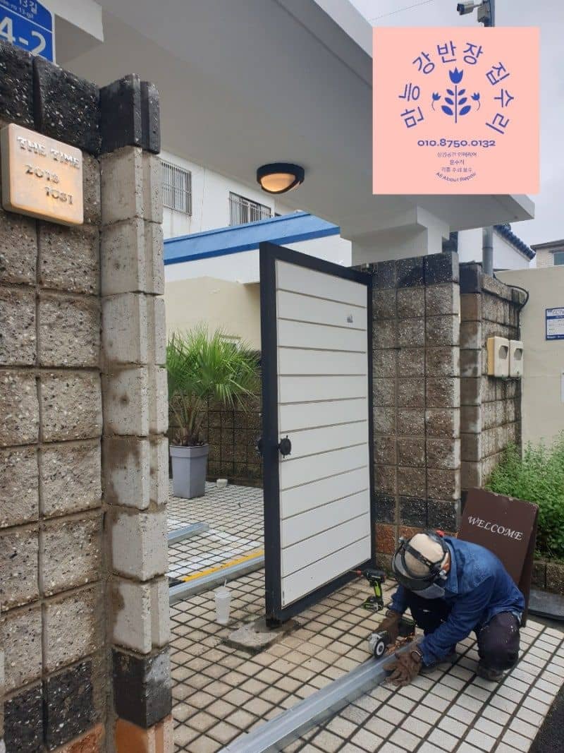 대문 하부 프레임을 그라인더로 절단하는 모습