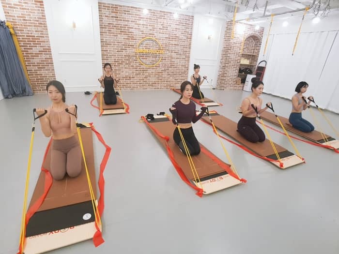 무릎을 꿇고 튜빙 밴드로 팔 근육 단련
