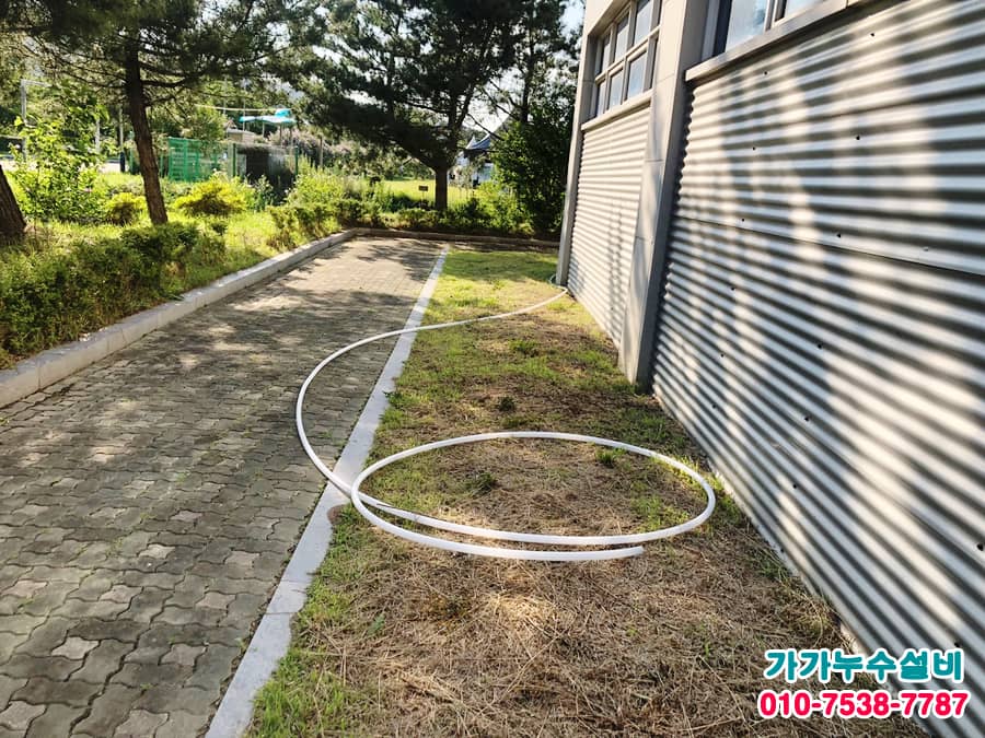 건물 외곽을 따라 길게 연장한 수도 배관 호스
